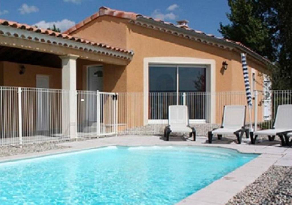 una piscina con 2 sillas y una casa en Villa Patio avec piscine Vallon Pont d'Arc Ardèche, en Sampzon
