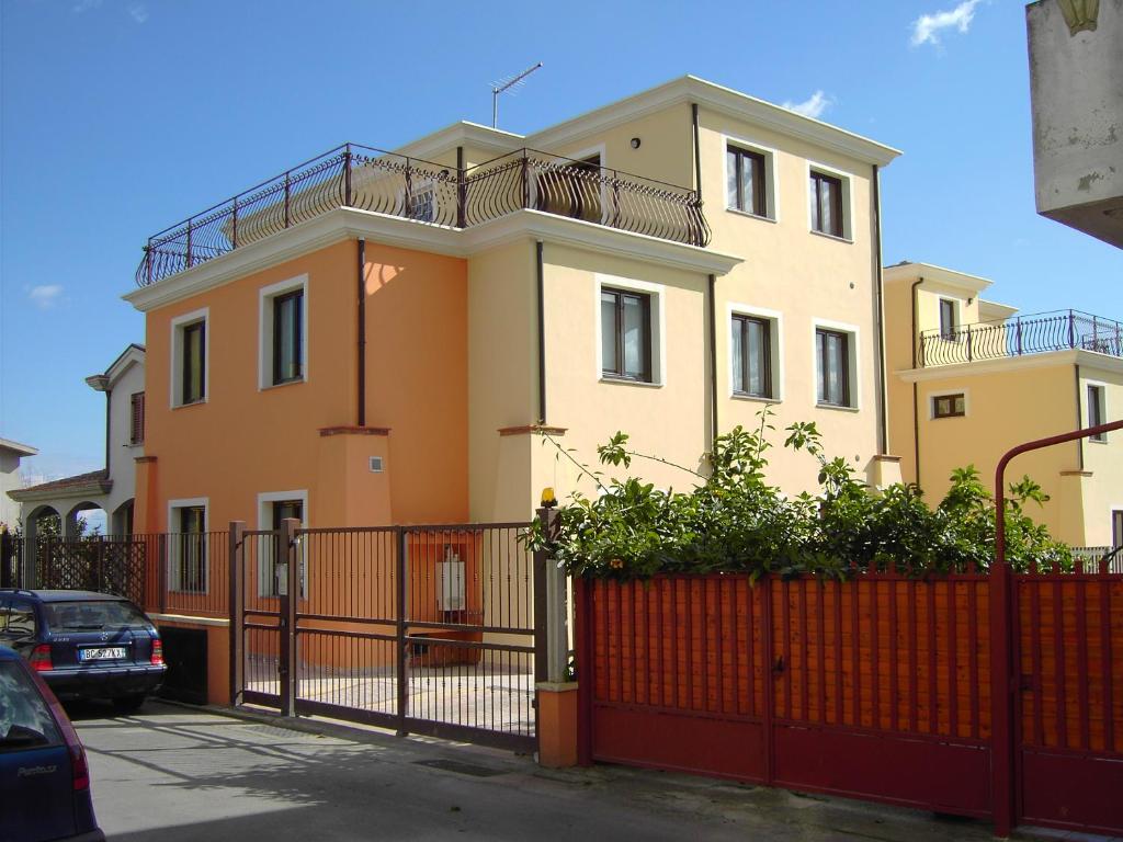 ein Gebäude mit einem orangenen Zaun davor in der Unterkunft Bertolottu Residence Apartments in Tortolì