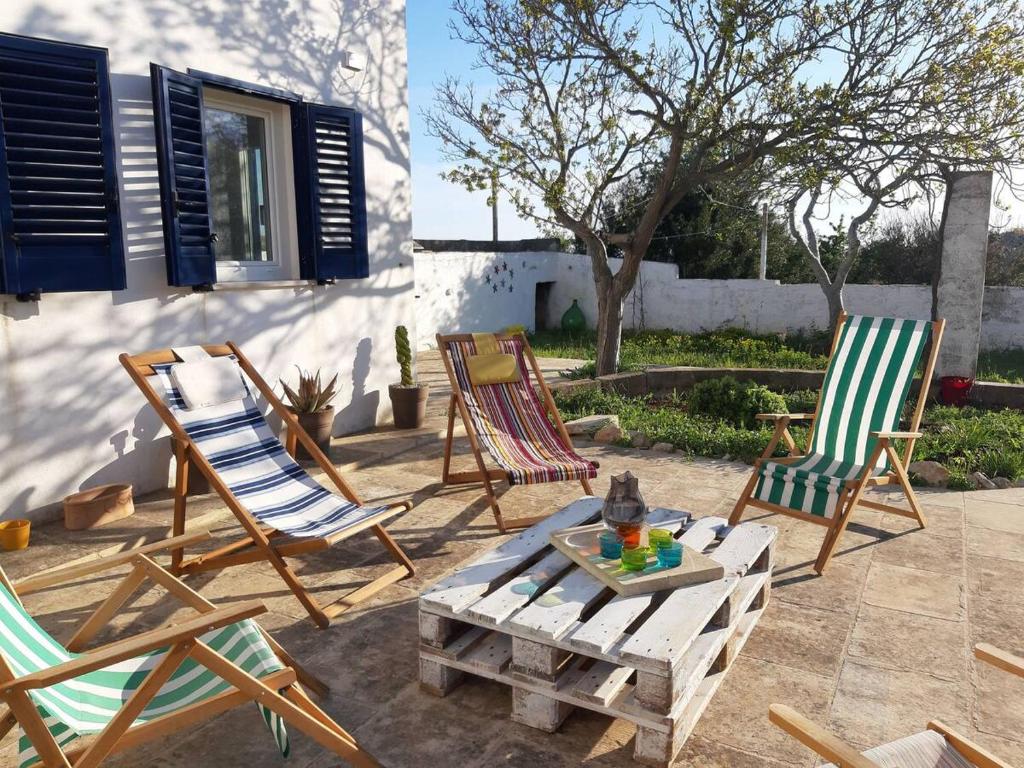 un grupo de sillas y una mesa de centro en un patio en Al Gelso Bianco appartamento, en Castrignano del Capo