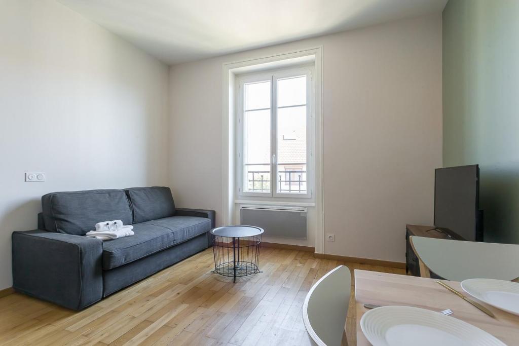 a living room with a couch and a table at Hamac Suites - Monplaisir fully equipped studio-2p in Lyon