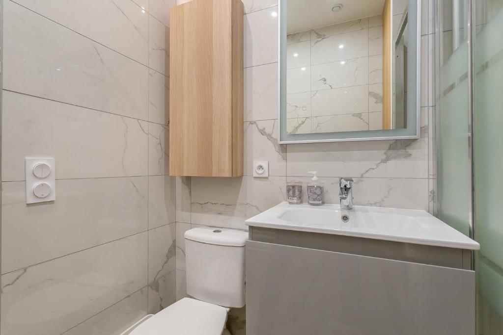 a white bathroom with a toilet and a sink at Hamac Suites - Monplaisir fully equipped studio-2p in Lyon