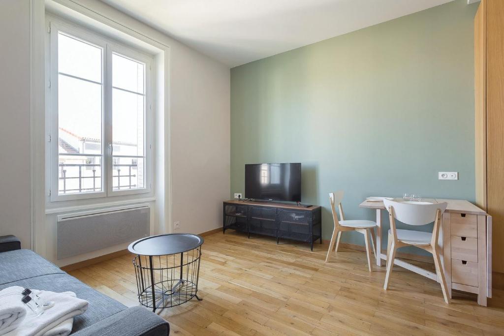 a living room with a couch and a table and a tv at Hamac Suites - Monplaisir fully equipped studio-2p in Lyon
