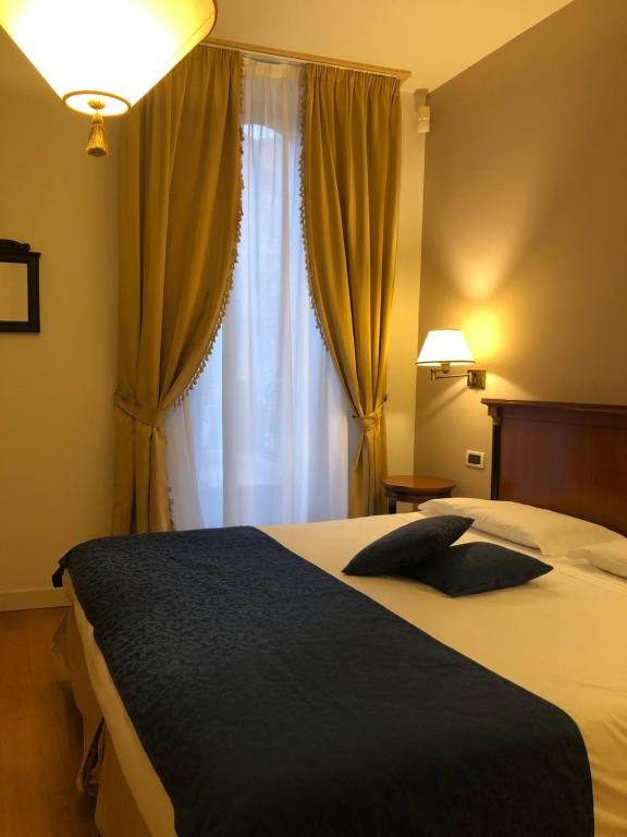 a bedroom with a bed and a window with curtains at Locanda del Ghetto in Venice
