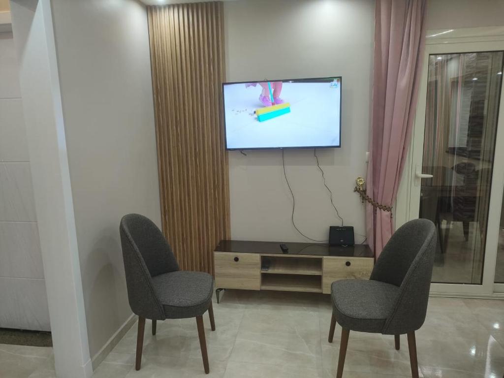 a living room with two chairs and a flat screen tv at المعمورة الشاطئ بالاسكندرية شارع سيف وانلي in Alexandria
