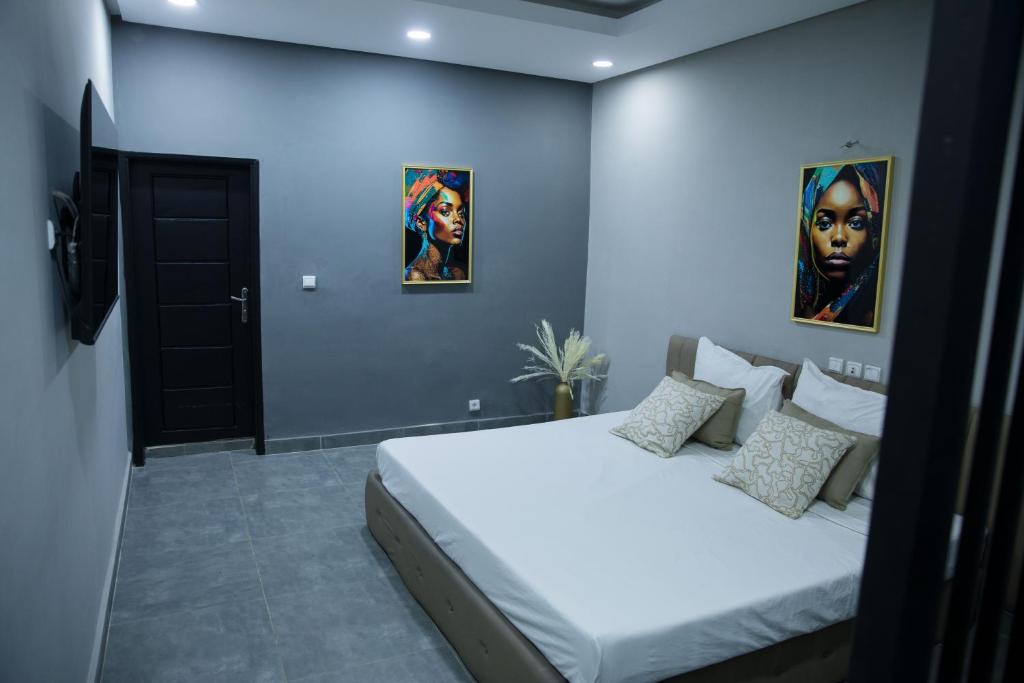 アビジャンにあるThe Shelter Abidjanのベッドルーム1室(ベッド1台付)が備わります。壁には絵画2点が飾られています。