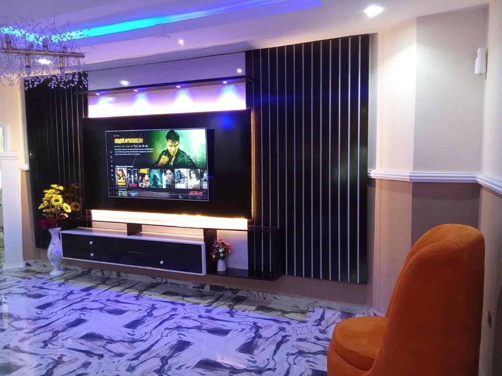 a living room with a flat screen tv on a wall at IMSMART Luxury Homes in Uyo