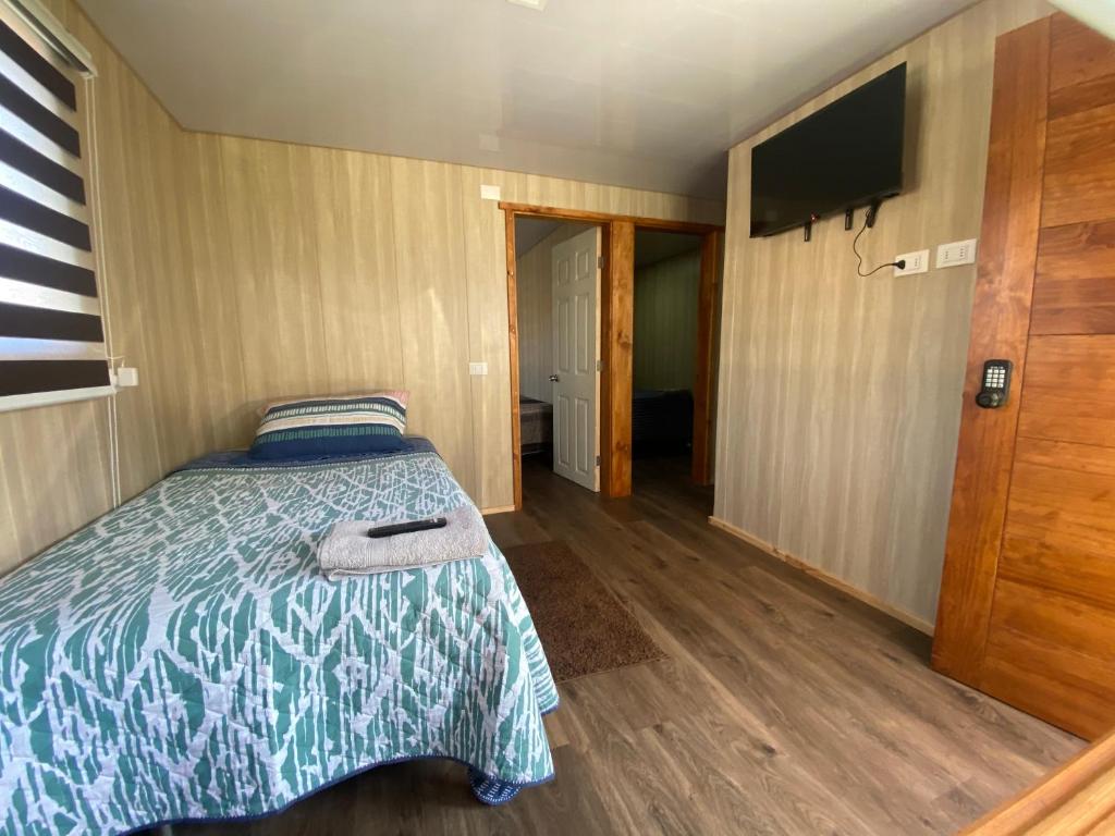 Schlafzimmer mit einem Bett und einem Flachbild-TV in der Unterkunft Alojamiento Rústico Belloto 4 in Quilpué