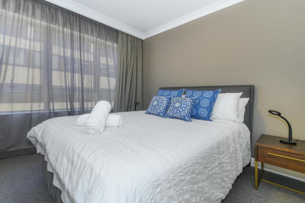 a bedroom with a large bed with blue and white pillows at Hotel styling entire one bedroom in Sydney