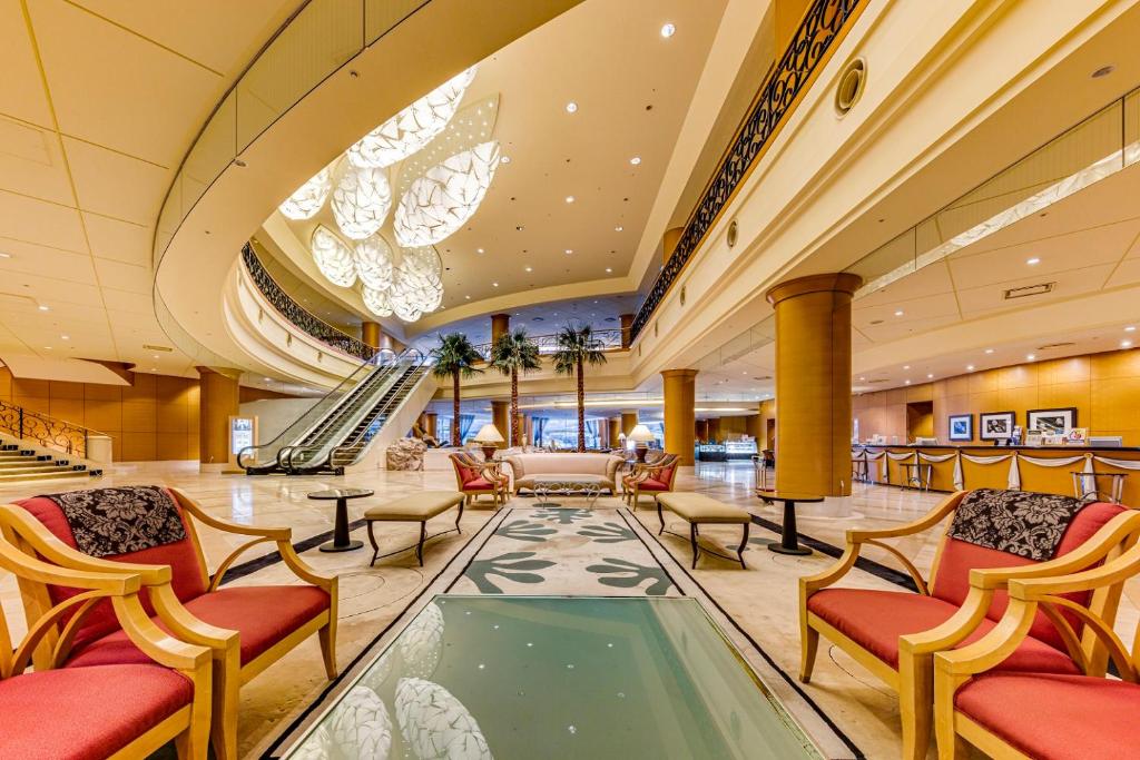 a hotel lobby with chairs and an escalator at Miyako Hotel Gifu Nagaragawa in Gifu