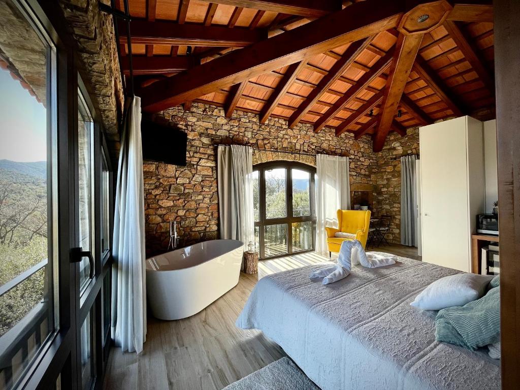 a bedroom with a large bed and a bath tub at Alojamiento MAS EL CASTELL DEL BRULL 