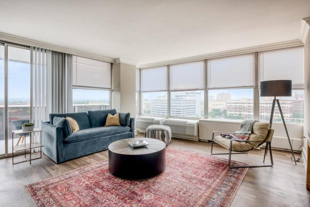 a living room with a blue couch and a large window at CozySuites 800 Tower 1BR w sky pool, gym! 24 in Louisville
