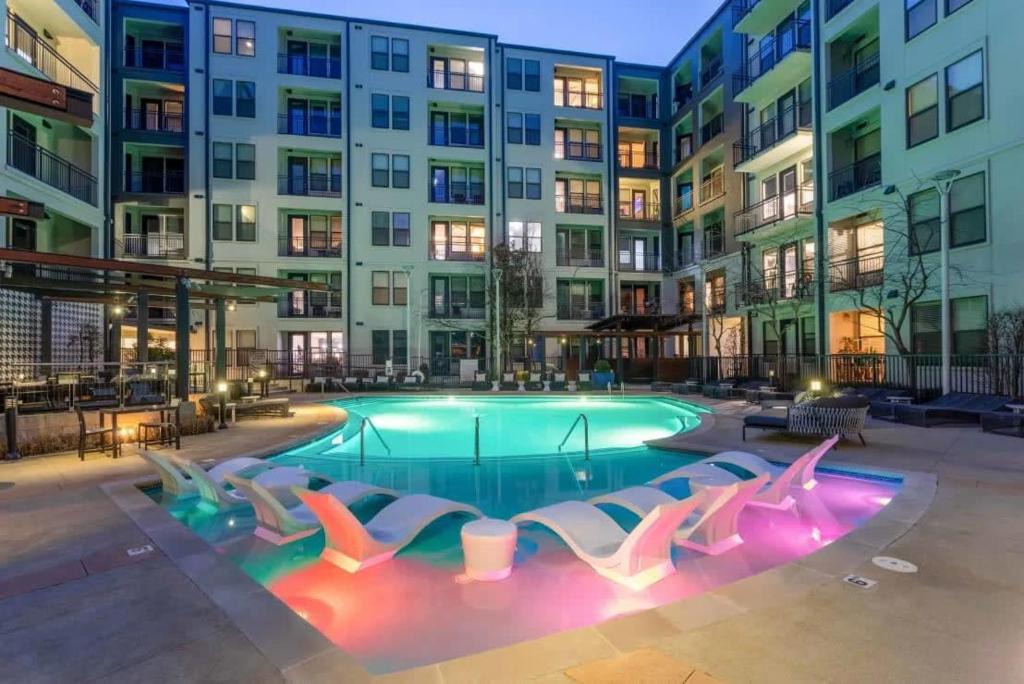 a swimming pool with lounge chairs in front of a building at CozySuites Modern Midtown Condo 04 in Nashville