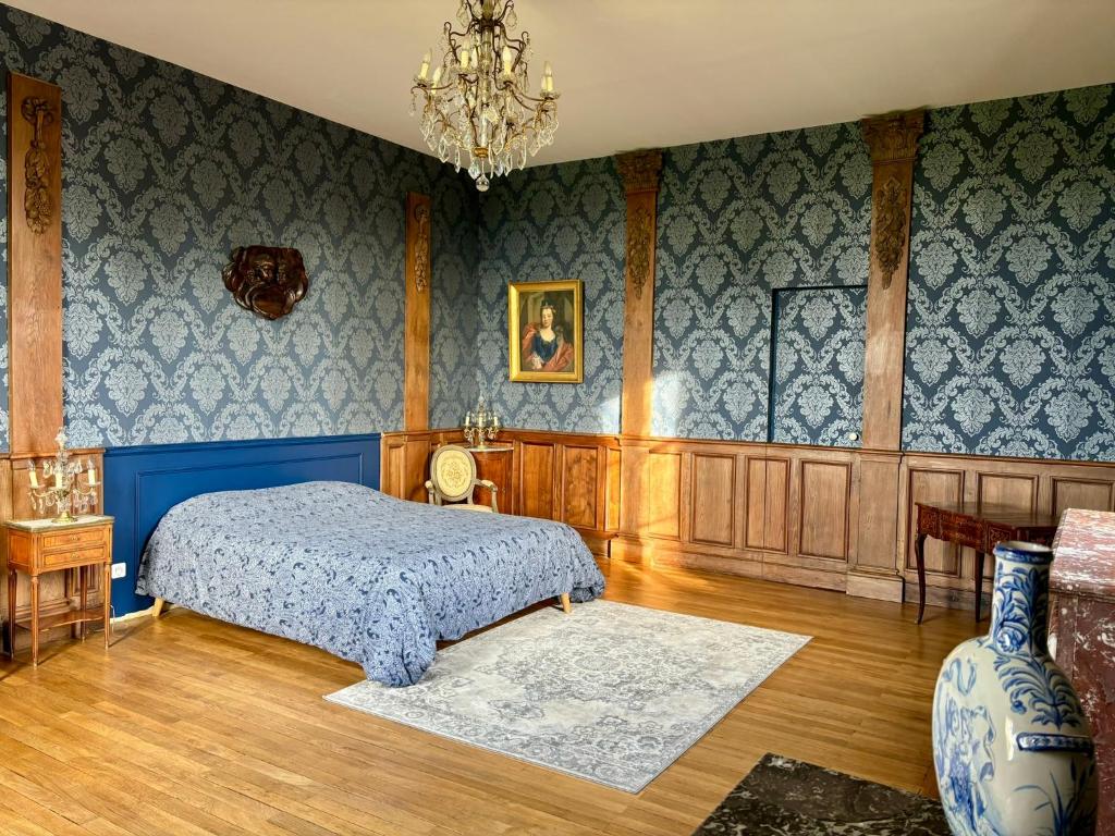 une chambre avec un lit et un lustre dans l'établissement Château de la Pervenchère gîte Baroque, à Casson