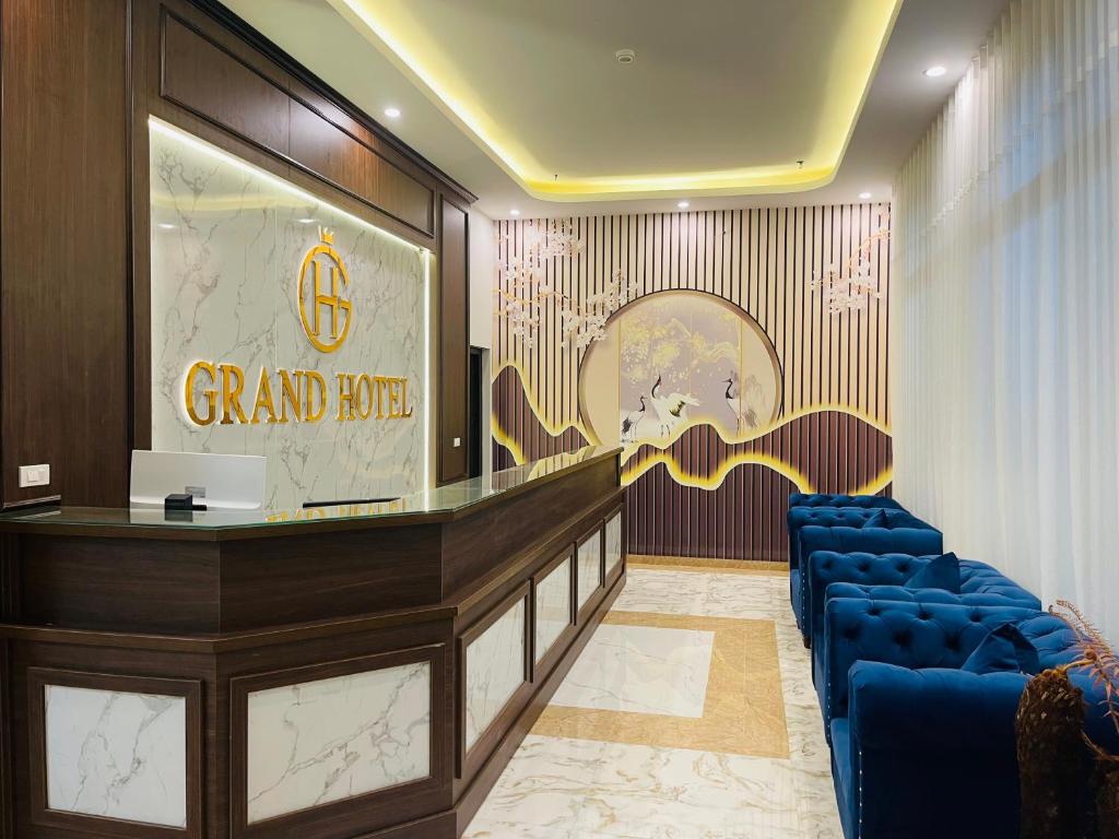 a lobby with a grand hotel sign and blue chairs at Grand Ha Noi Hotel in Hanoi