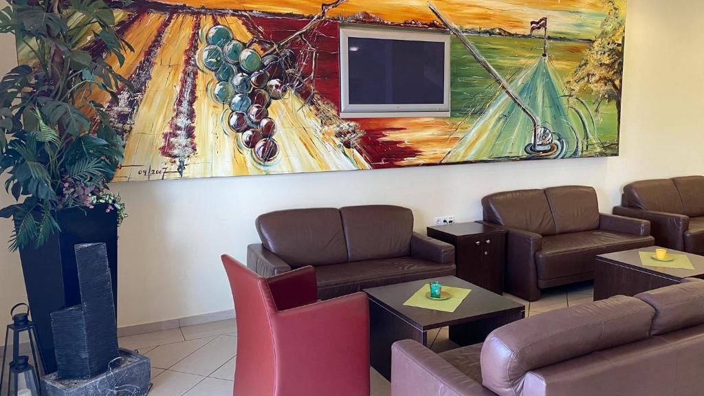 a waiting room with couches and a painting on the wall at Weinland in Donnerskirchen
