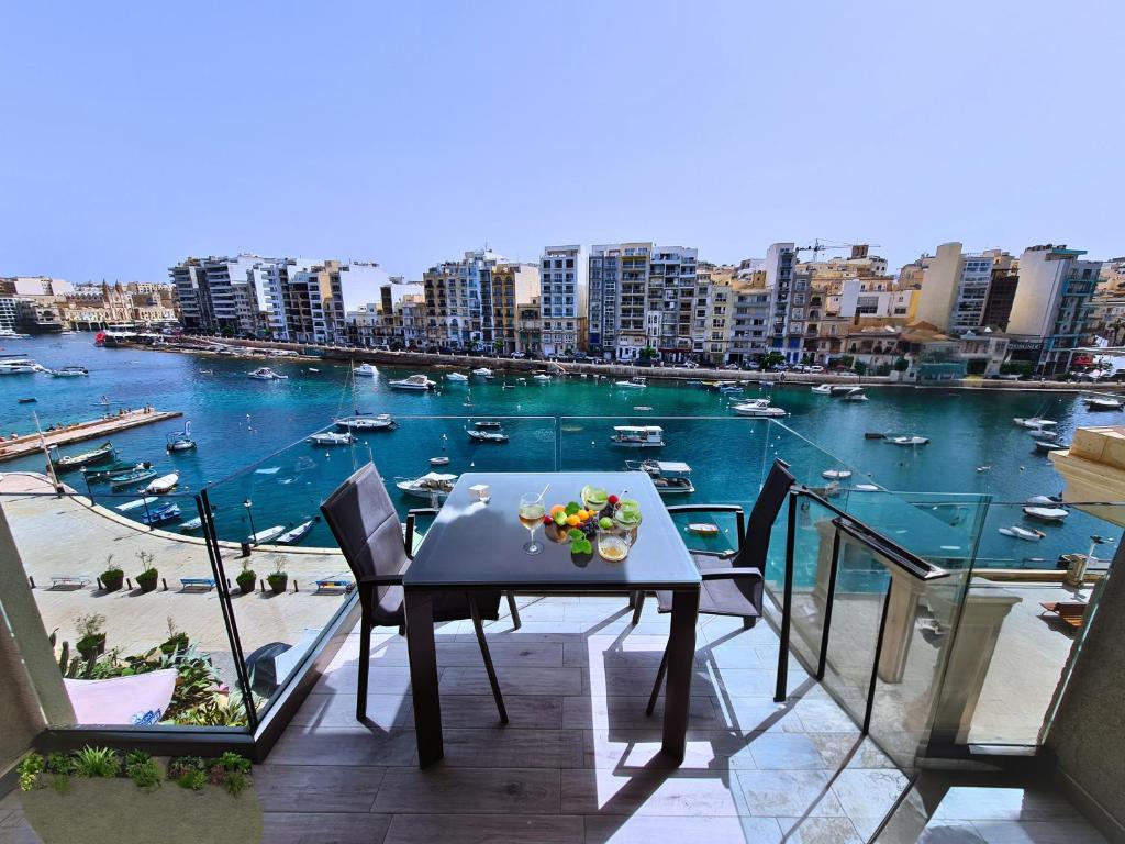 una mesa en un balcón con vistas al puerto en Supreme Seafront apt with Balcony in St.Julian's, en San Julián