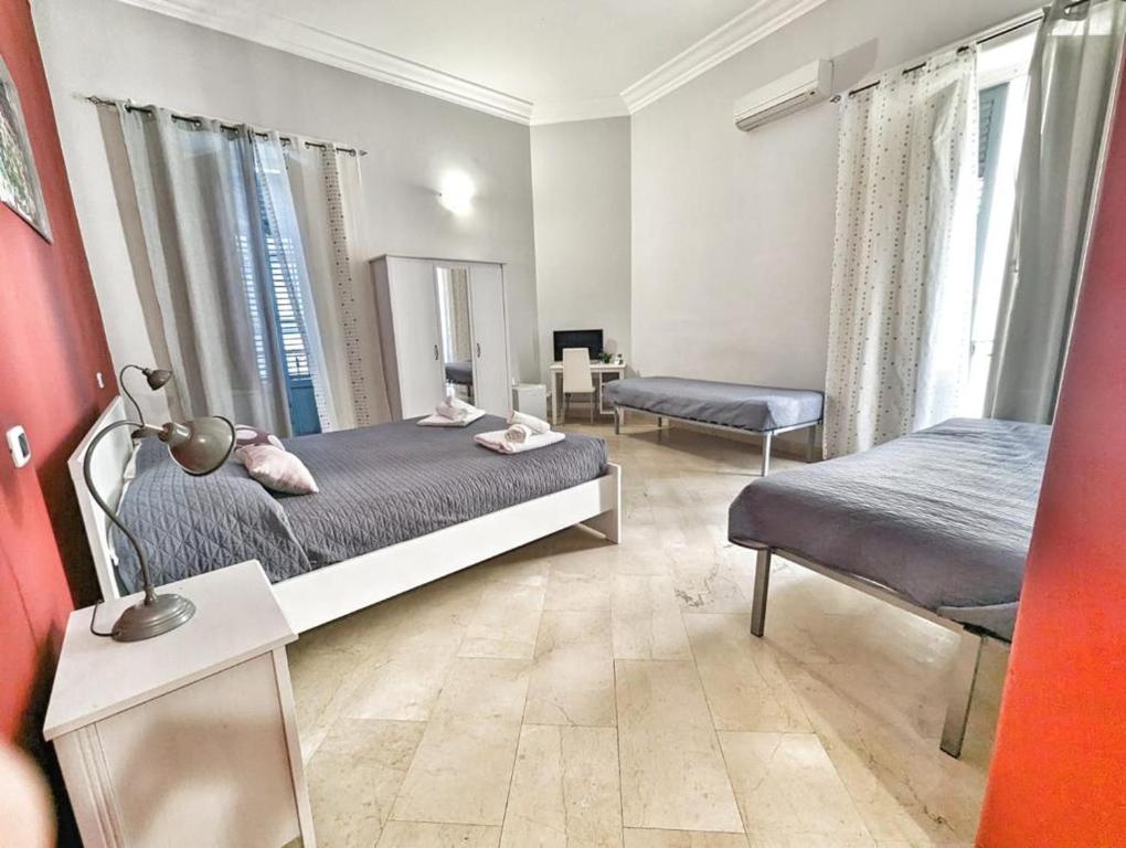 una camera con due letti e uno specchio di B&B Villareale 35 a Palermo