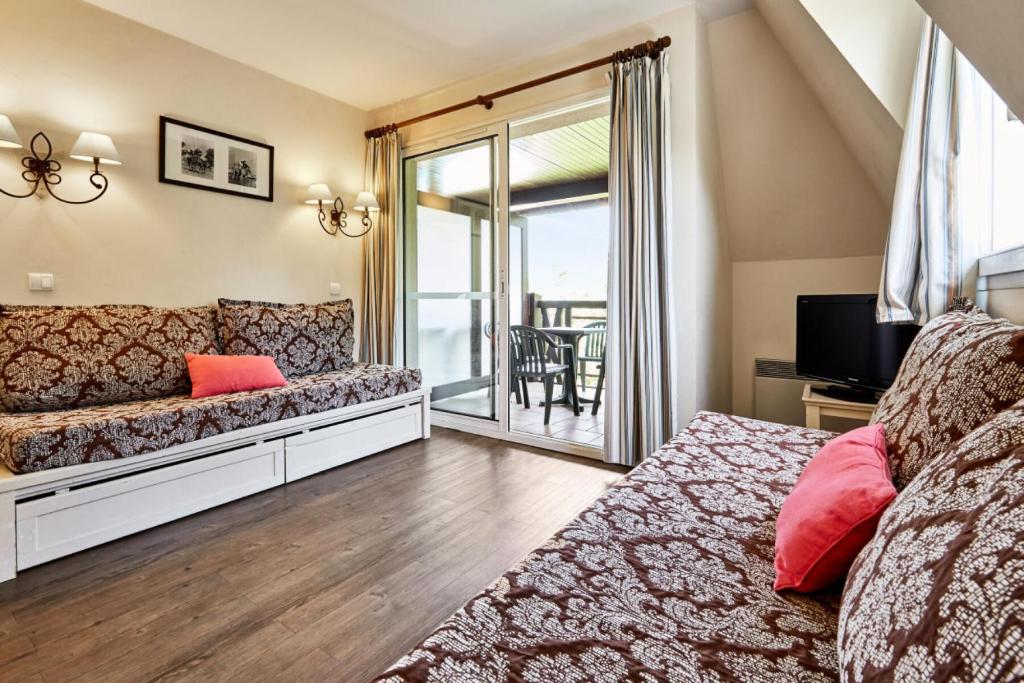 d'un salon avec un canapé et un balcon. dans l'établissement La Résidence du Golf - maeva Home - Appartement 2 pièces 4 personnes Selection MAE-1110, à Deauville