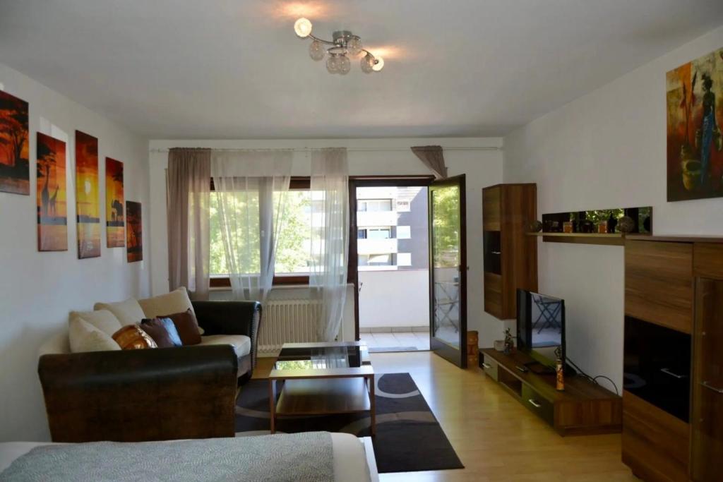 een woonkamer met een bank en een tafel bij ATRIUM - geräumige Wohnung GIESEN in Oftersheim