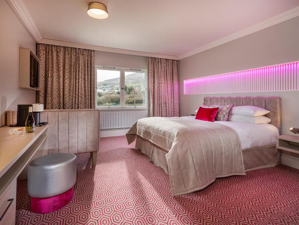 Four Seasons Hotel, Carlingford في كارلينغفورد: غرفة فندقية بسرير كبير ونافذة