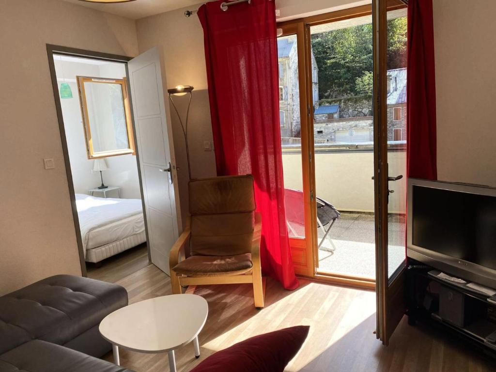 - un salon avec un canapé, une chaise et une fenêtre dans l'établissement Résidence Bois De Marie - Appartement avec garage et WIFI, proche du centre de Barèges MAE-8724, à Barèges