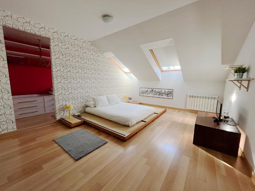 a bedroom with a bed and a wooden floor at Dúplex Valle del Silencio in Ponferrada