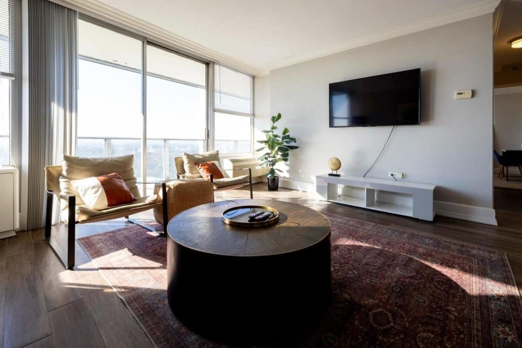 a living room with a couch and a table at CozySuites 800 Tower 2BR w/sky pool, gym! 32 in Louisville