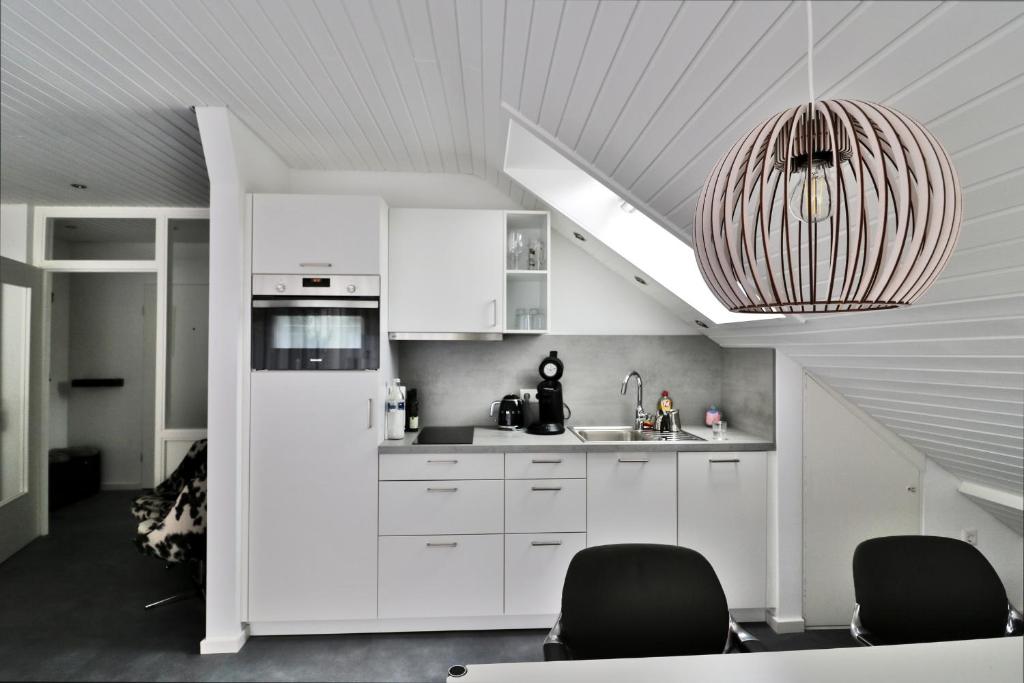une cuisine avec des placards blancs et un plafond dans l'établissement Ferienwohnung "Hygge" in Schluchsee, à Schluchsee