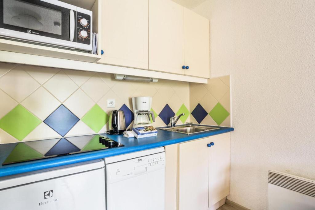 a small kitchen with a sink and a microwave at Résidence Saint-Raphaël Valescure - maeva Home - Studio 2 personnes - Séle 41 in Valescure
