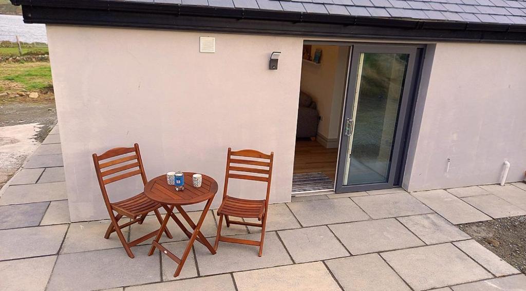 uma mesa e duas cadeiras sentadas num pátio em 380 The Bothy Cleggan em Leagaun