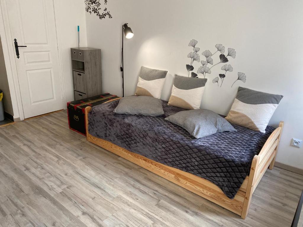 Un dormitorio con una cama con almohadas. en Studio centre village Soligny la Trappe proche Mortagne au perche, en Soligny-la-Trappe