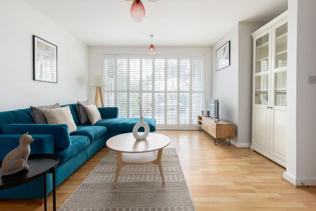 a living room with a blue couch and a table at The East Dulwich Collection in London