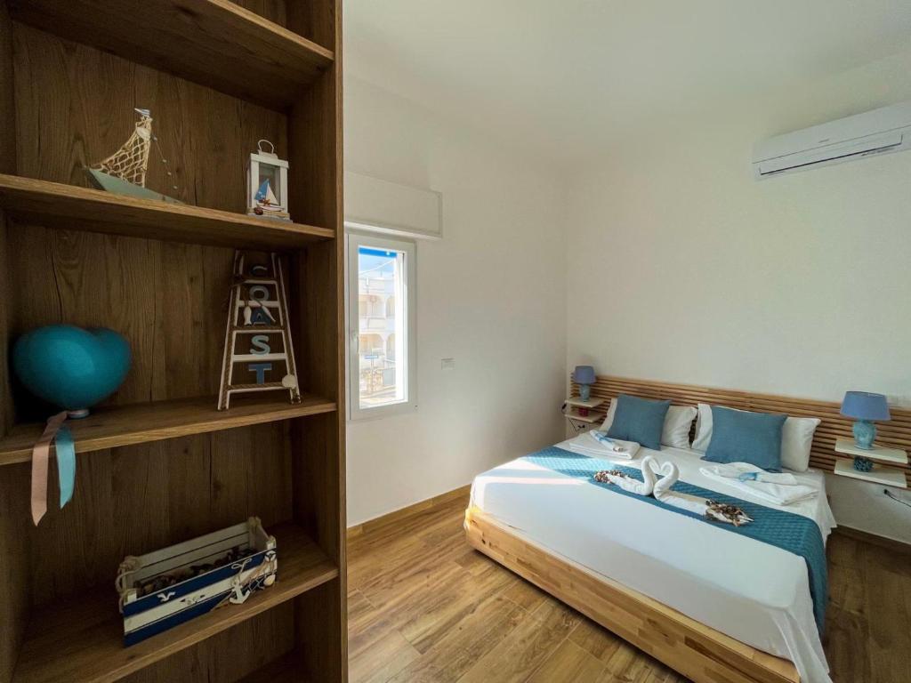 1 dormitorio con cama y estante para libros en Appartamenti Calliope, en San Foca