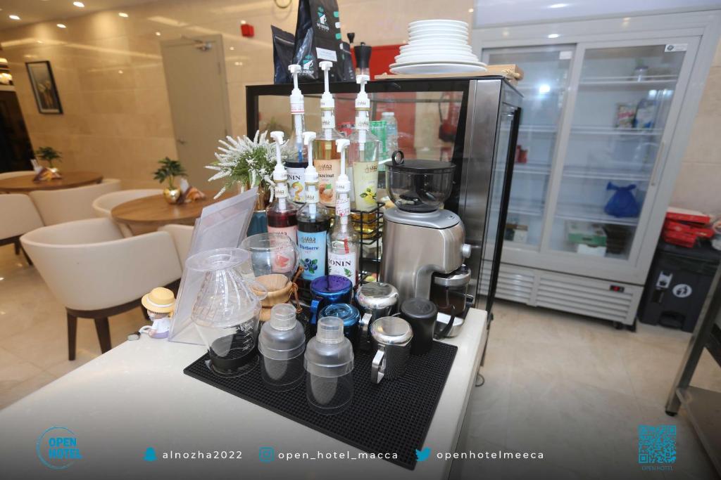 una mesa con cafetera y botellas en ella en فندق اوبن هوتيل مكه المكرمه en La Meca