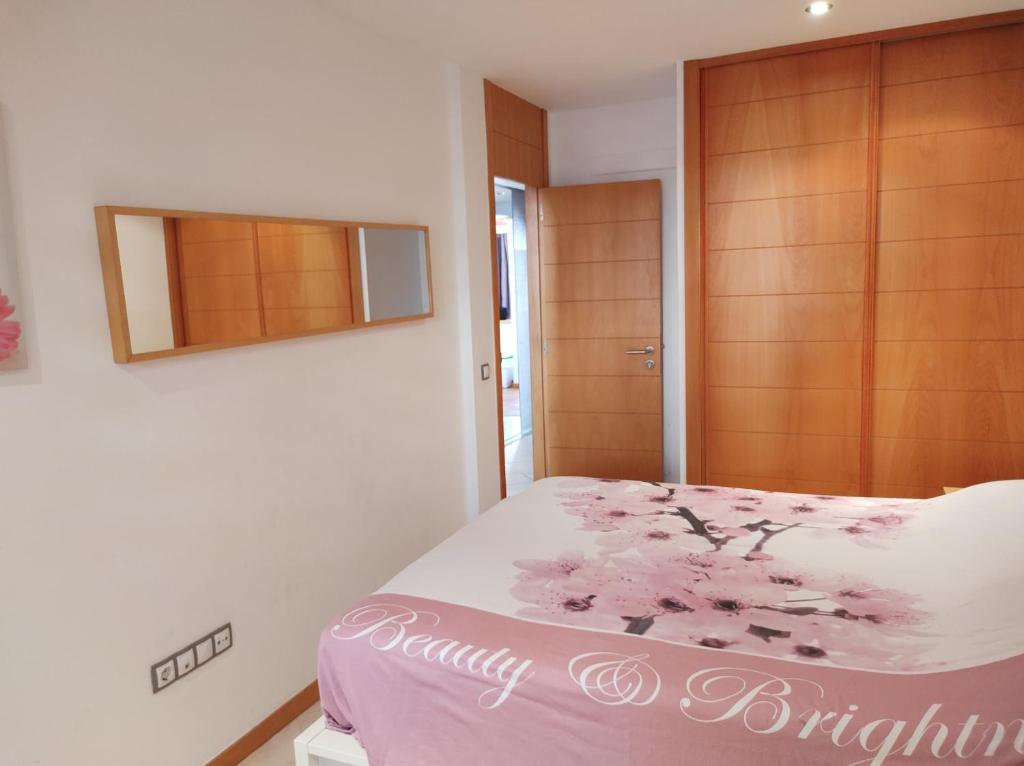 プラヤ・パライソにあるAdeje paradiseのベッドルーム1室(ピンクの花が咲くベッド1台付)