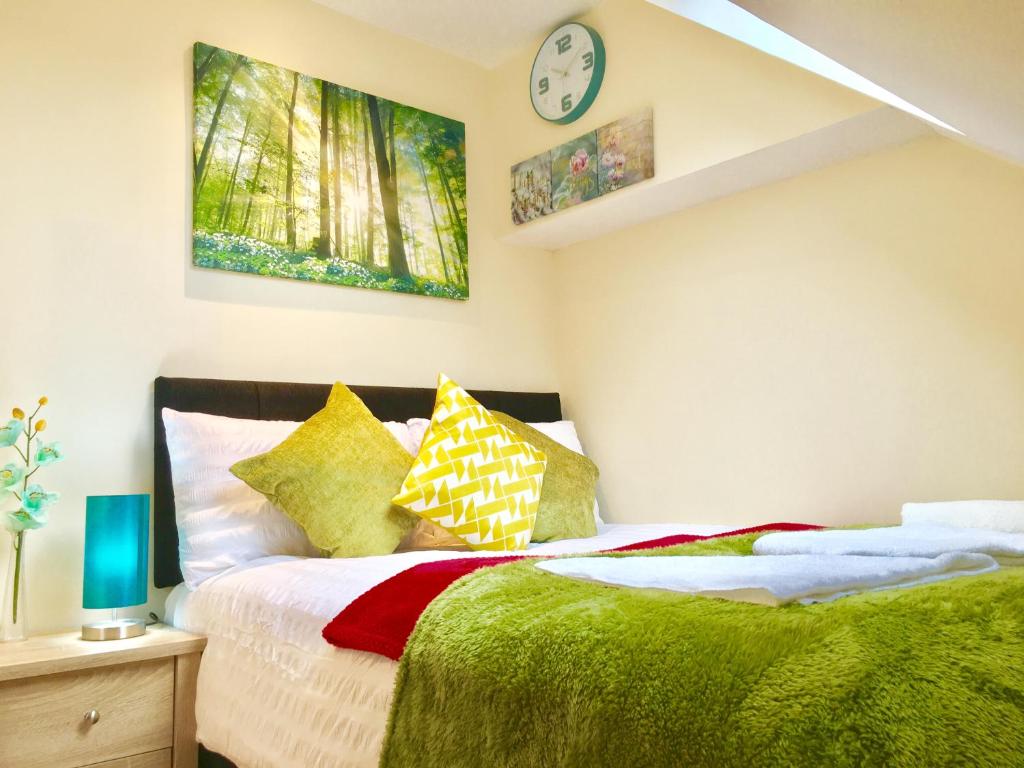 sypialnia z 2 łóżkami i zegarem na ścianie w obiekcie 1 Bed Apartment,Recep,Kitchen,Bath w mieście Ilford