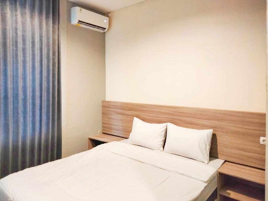 1 dormitorio con cama y ventana en Wi Kost Premiere Inn Mitra RedDoorz 