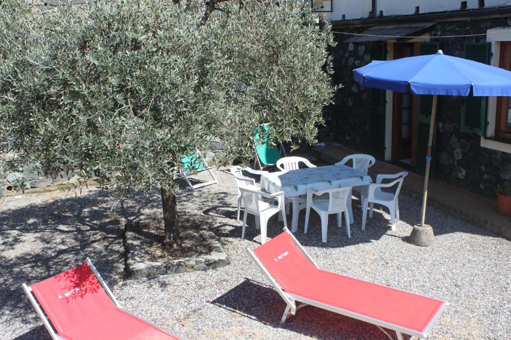 eine Terrasse mit einem Tisch, Stühlen und einem Sonnenschirm in der Unterkunft L'ulivo in Levanto
