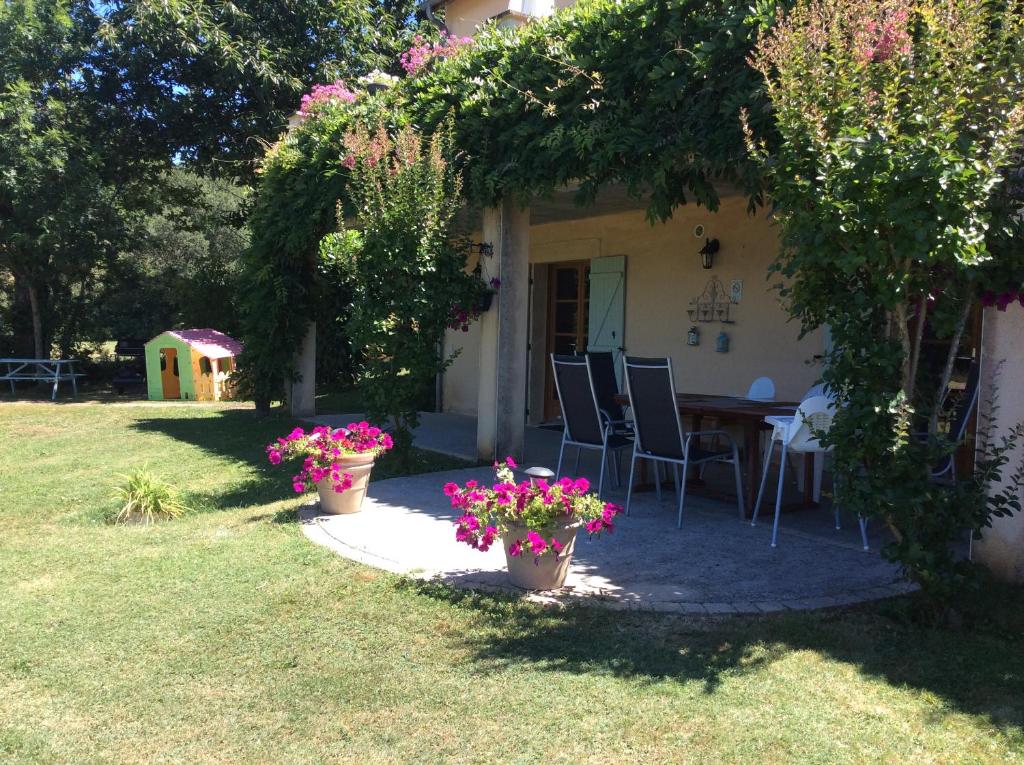 a house with a table and chairs and flowers at Les Jonquilles in Domme