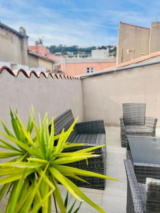 un patio avec des chaises, une table et une plante dans l'établissement ''Brave Margot'' Cosy T2 avec clim et terrasse, à Sète