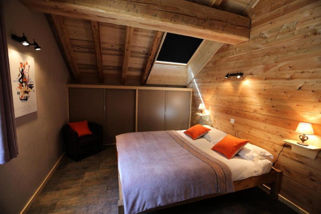 una camera con letto e parete in legno di Les Chalets D'adrien - 3 Pièces pour 6 Personnes 84 a Valloire