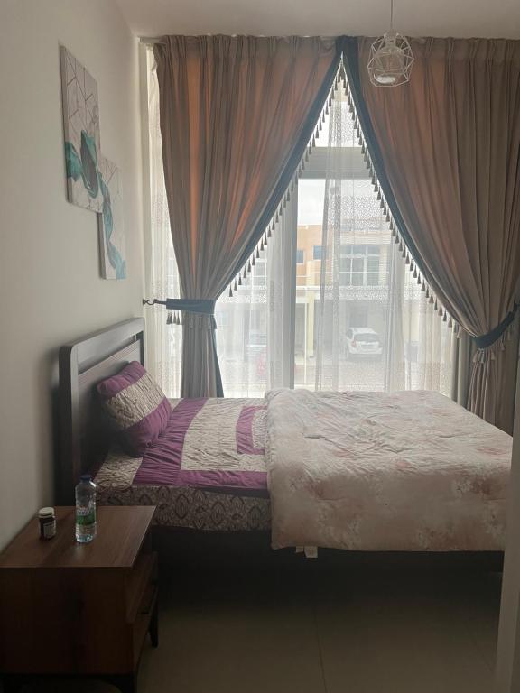 una camera con un letto e una grande finestra di Shared Villa in Damac Hills 2 - Female only a Dubai