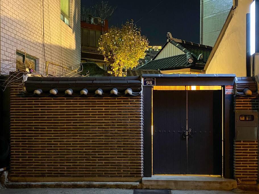 una valla de madera con una puerta y un edificio en Hanok guesthouse Ann, 