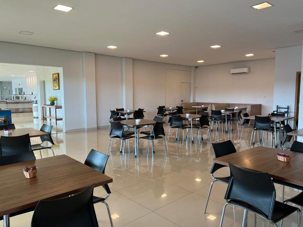 a restaurant with tables and chairs in a room at Hotel PetroShop in Palmas