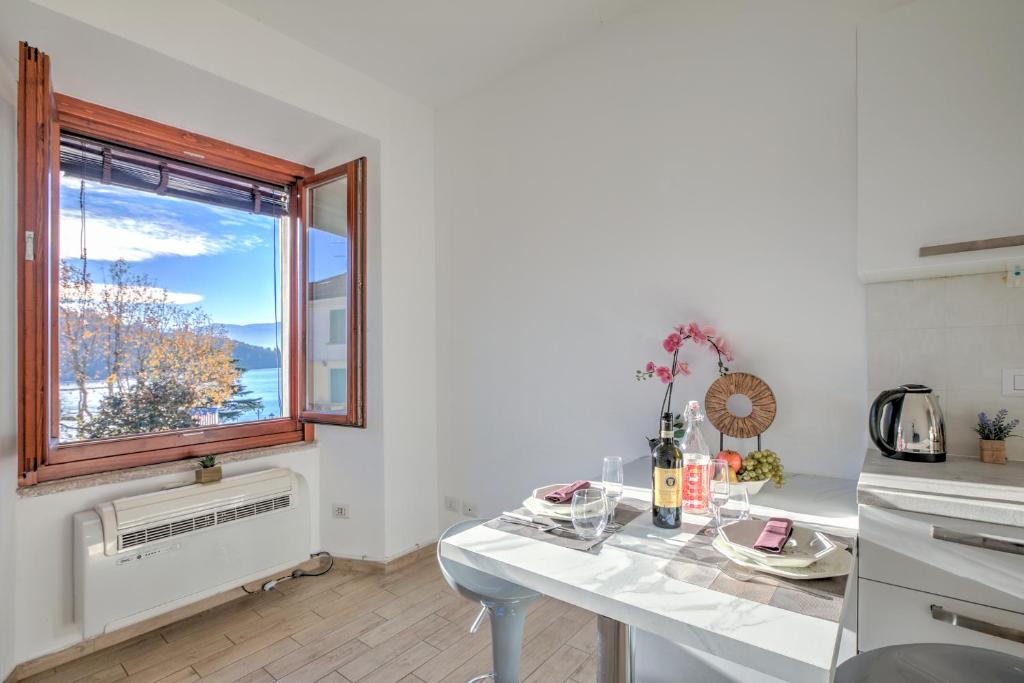 a kitchen with a white table and a window at La Finestra di Laura - Happy Rentals in Laveno-Mombello