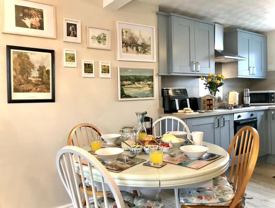 a kitchen with a table and chairs with food on it at Charming Coastal Getaway - Pembroke in Pembrokeshire