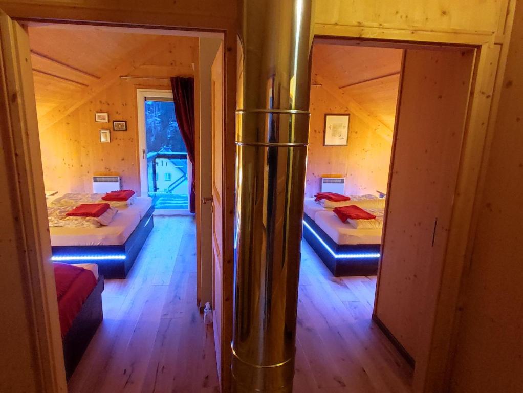 um quarto com duas camas e um espelho em Wohlfuehl-Chalet-Alpengloeckchen em Stadl an der Mur