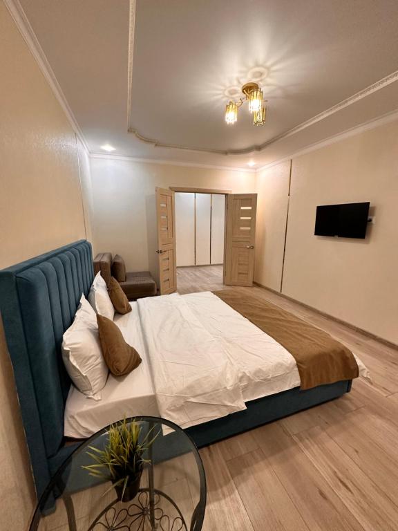 um quarto com uma cama e uma mesa de vidro em Аблайхана 1/3 em Kokshetau