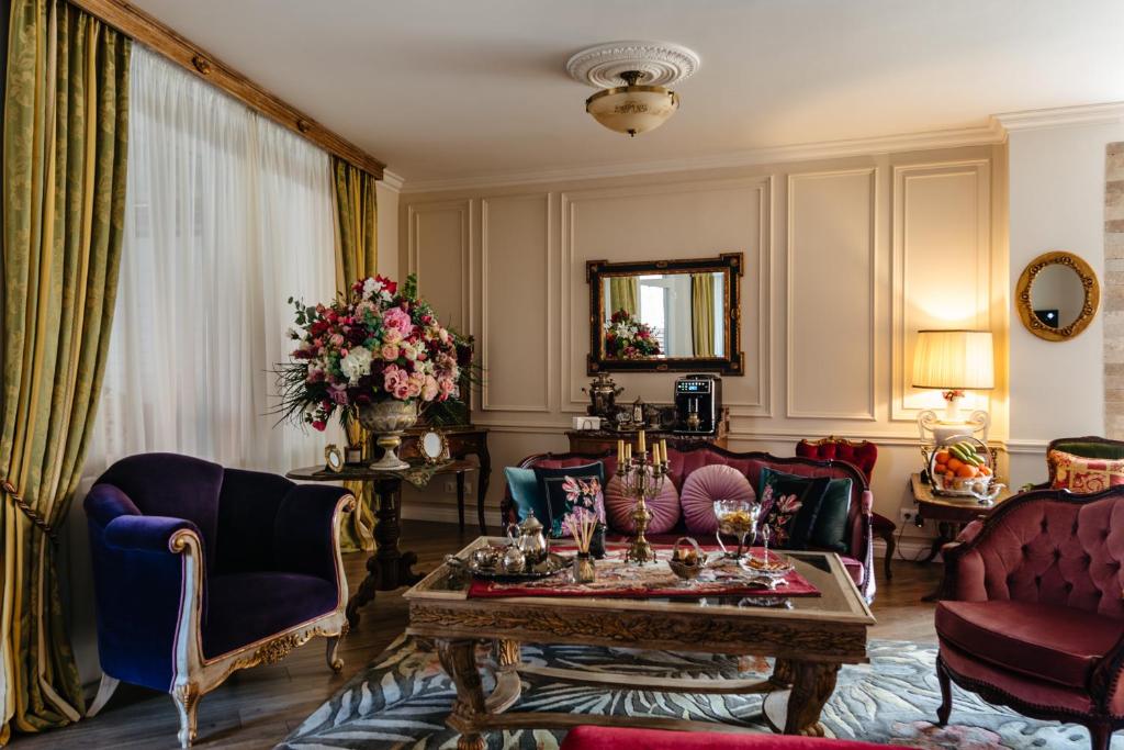 a living room with purple chairs and a table at Ateneea Luxury Rooms in Cluj-Napoca