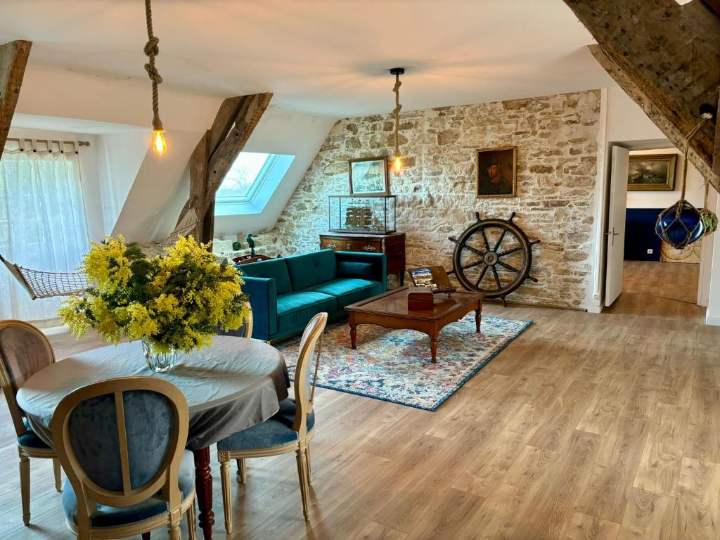 een woonkamer met een blauwe bank en een tafel bij Château de la Pervenchère gîte Marin in Casson
